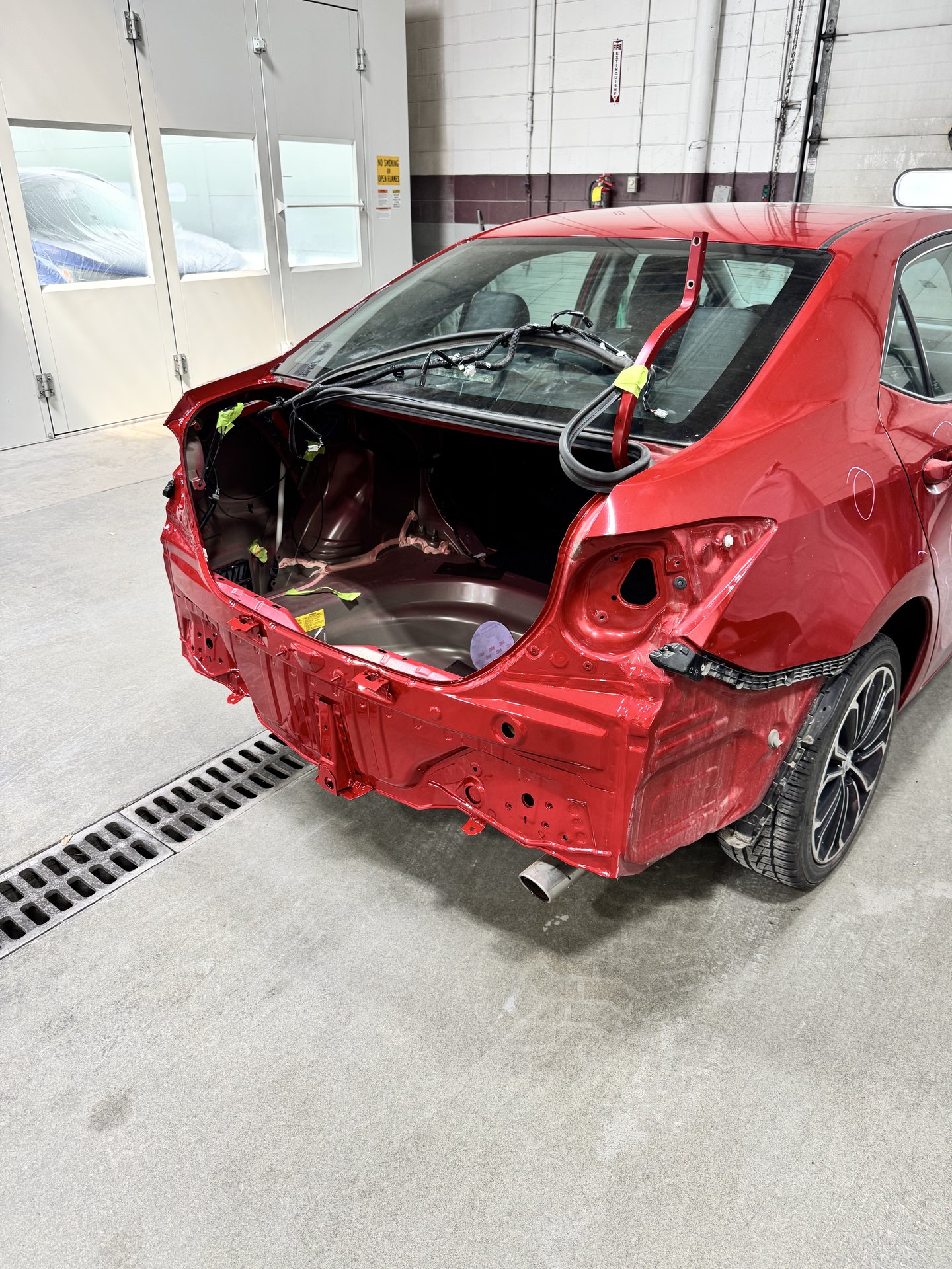 2015 Toyota Corolla with rear-end collision damage stripped of bumper and trunk panel during repair at Bob Rohrman Collision Repair Center in Lafayette, Indiana
