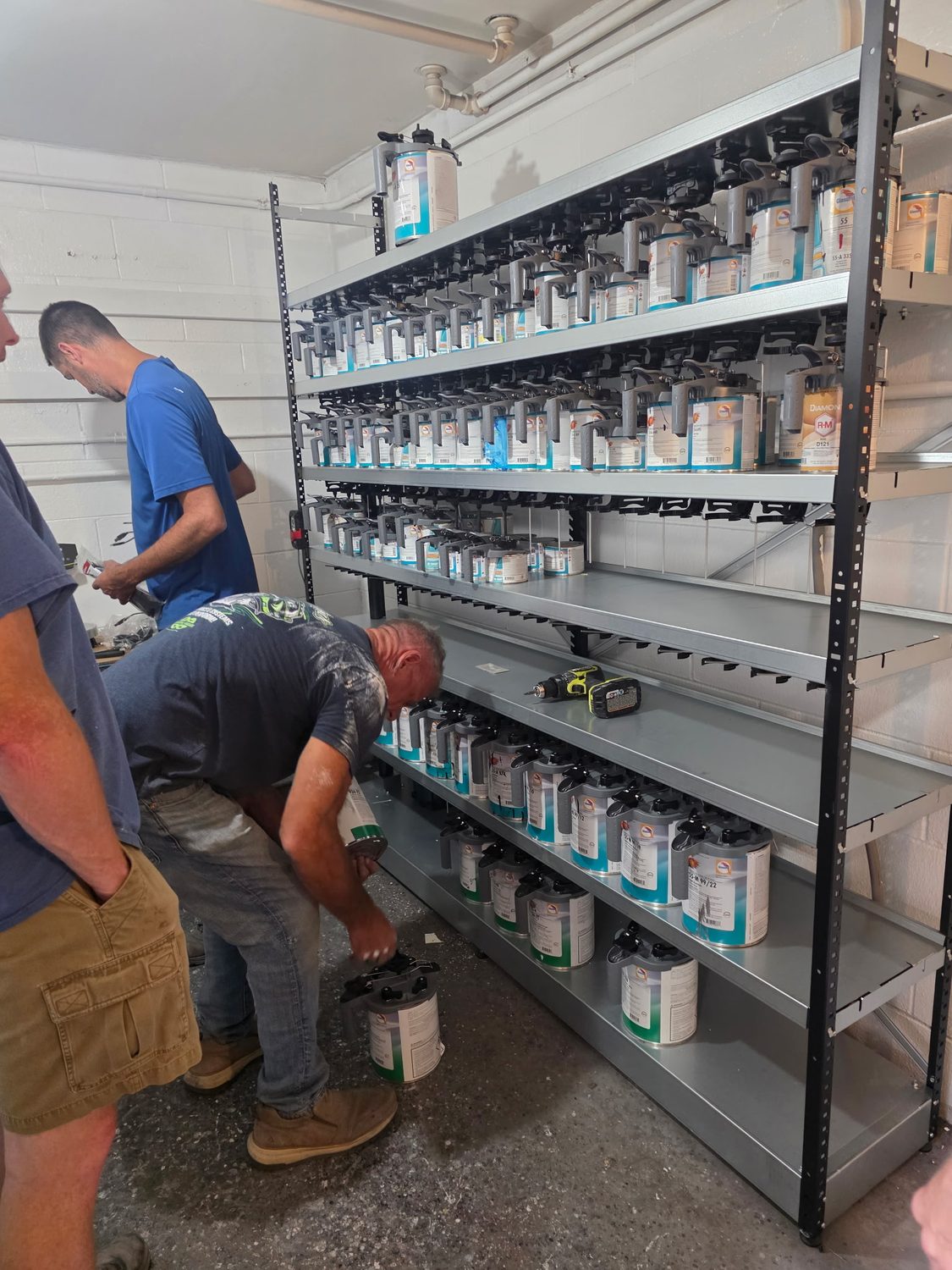 Crew stocking new shelving with BASF paint toners during the mixing room remodel at Bob Rohrman Collision Repair Center, Lafayette IN
