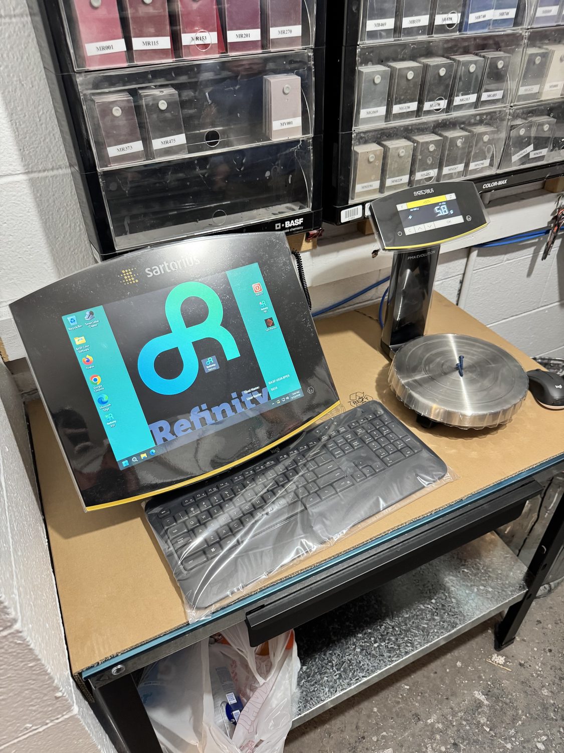 New Sartorius precision paint mixing scale with a stainless weighing pan and digital readout beside BASF toner racks at Bob Rohrman Collision Repair Center in Lafayette, Indiana